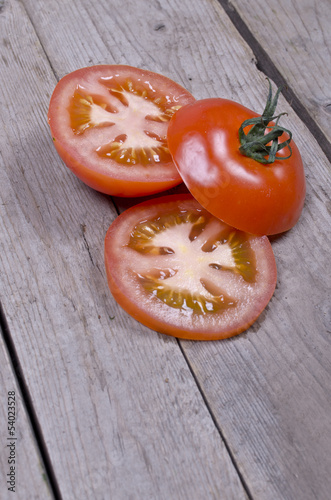 Photo: Organic sliced tomatoes on wooden background Organic sliced tomatoes on wooden background