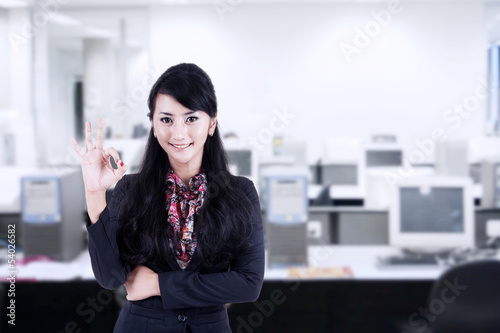 Photo: Businesswoman approval gesture at office Businesswoman approval gesture at office