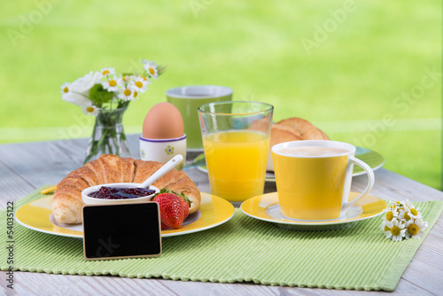 Photo: schild steht vor frühstücksgedeck schild steht vor frühstücksgedeck