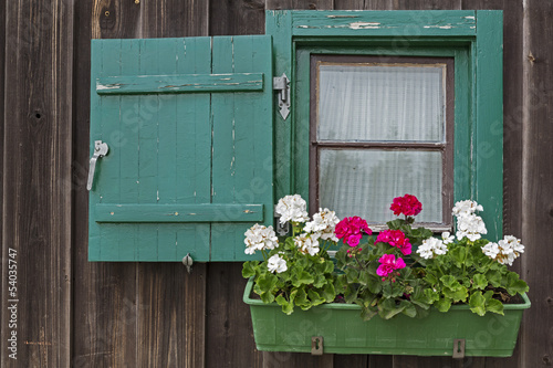 Photo: Kleines Fenster an einer Berghütte mit Geranien Kleines Fenster an einer Berghütte mit Geranien