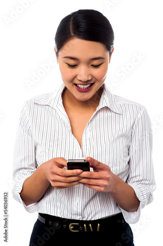 Photo: Woman sending text message to her colleague Woman sending text message to her colleague