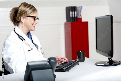 Photo: Lady doctor working on computer Lady doctor working on computer