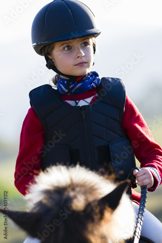 Photo: Horse riding - lovely girl is riding on a horse Horse riding - lovely girl is riding on a horse