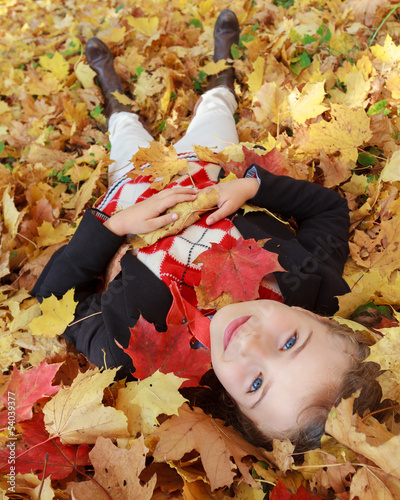 Photo: Autumn fun - lovely girl playing in autumn park Autumn fun - lovely girl playing in autumn park