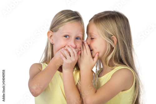 Photo: Little girl whispering to her sister Little girl whispering to her sister