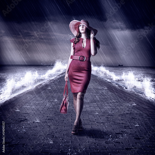 Photo: Young fashion woman is on pier during storm Young fashion woman is on pier during storm