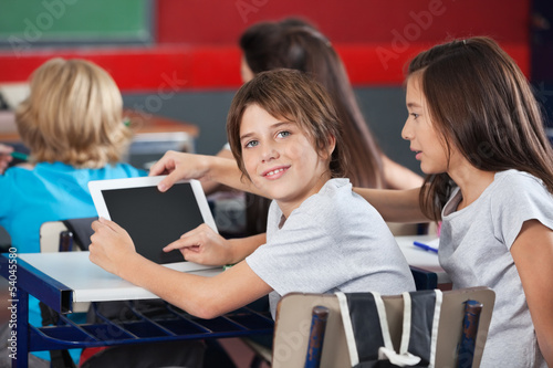 Photo: Boy With Girl Using Digital Tablet At Desk Boy With Girl Using Digital Tablet At Desk