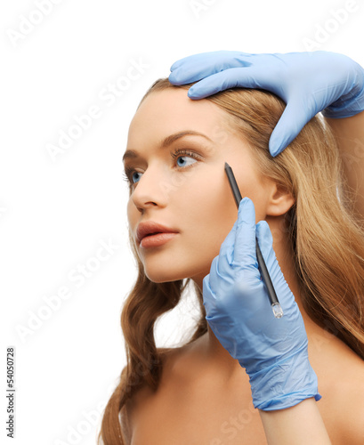 Photo: woman face and beautician hands with pencil woman face and beautician hands with pencil