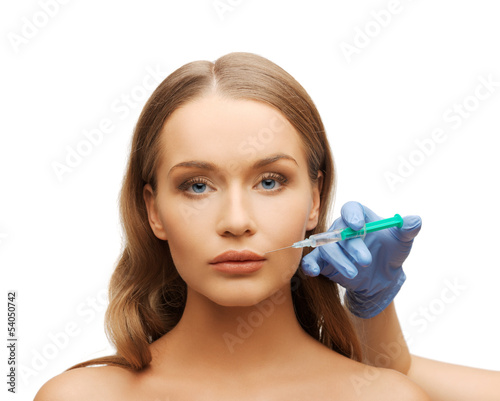 Photo: woman face and beautician hands with syringe woman face and beautician hands with syringe