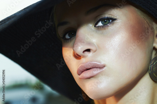 Photo: close-up portrait of beautiful woman in hat. green eyes close-up portrait of beautiful woman in hat. green eyes