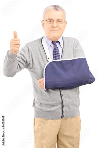 Photo: Senior man with broken arm giving thumb up Senior man with broken arm giving thumb up