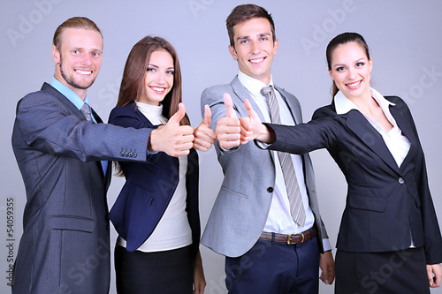 Photo: Business team standing in row on grey background Business team standing in row on grey background