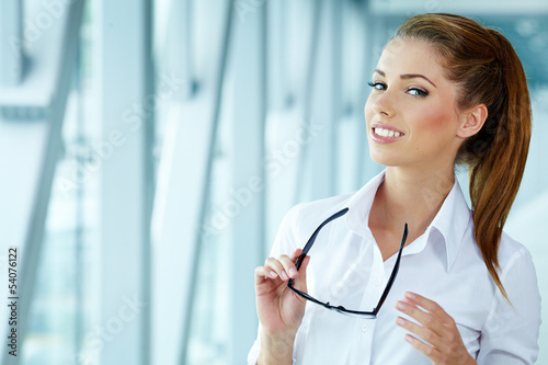 Photo: Portrait of happy smiling young businesswoman in office Portrait of happy smiling young businesswoman in office