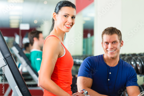 Photo: Trainer und Mann mit Hanteln im Fitness studio Trainer und Mann mit Hanteln im Fitness studio