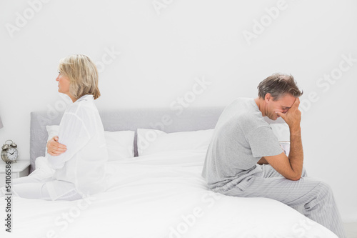 Photo: Couple sitting on opposite sides of bed Couple sitting on opposite sides of bed