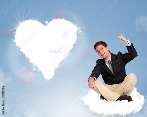 Photo: Handsome man sitting on cloud with heart Handsome man sitting on cloud with heart