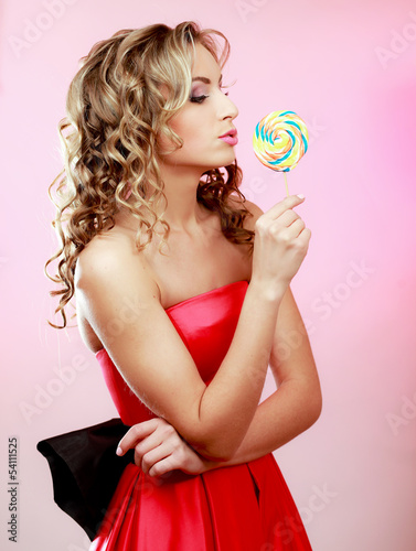 Photo: young happy woman with lollipop, isolated on pink background young happy woman with lollipop, isolated on pink background