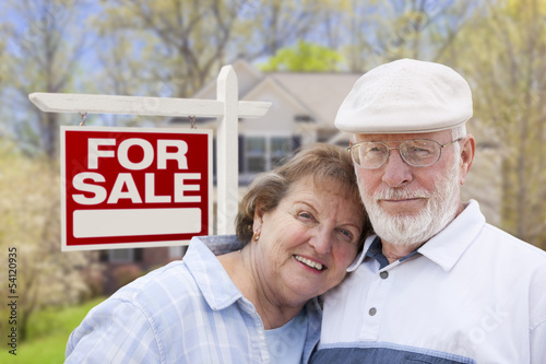 Photo: Retired Senior Couple Front of For Sale Sign and House Retired Senior Couple Front of For Sale Sign and House