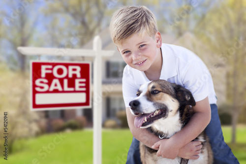 Photo: Young Boy and His Dog in Front of For Sale Sign and House Young Boy and His Dog in Front of For Sale Sign and House
