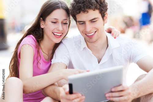 Photo: Young couple looking at digital tablet Young couple looking at digital tablet