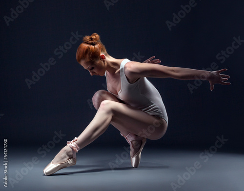 Photo: Graceful slender ballerina dancing in studio Graceful slender ballerina dancing in studio