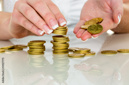 Photo: Frau mit Münzstapel beim Geld sparen Frau mit Münzstapel beim Geld sparen