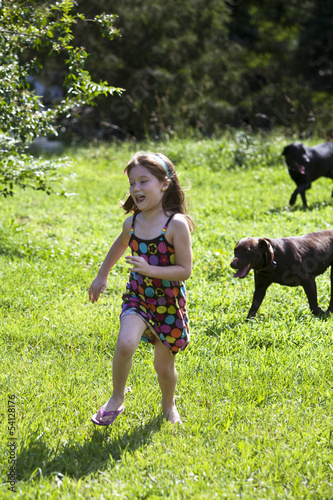 Photo: Young girl running from dogs Young girl running from dogs