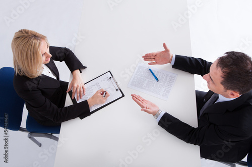 Photo: Two Businesspeople Talking With Each Other Two Businesspeople Talking With Each Other