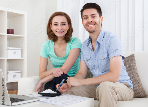 Photo: Young couple calculating budget Young couple calculating budget
