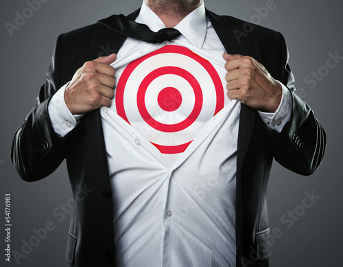 Photo: Young businessman tearing his shirt off to show target symbol Young businessman tearing his shirt off to show target symbol