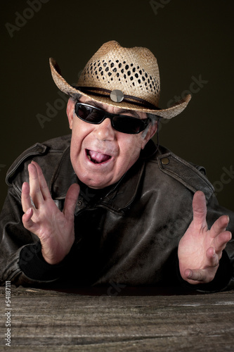 Photo: Confused man with hat and sunglasses in black background Confused man with hat and sunglasses in black background