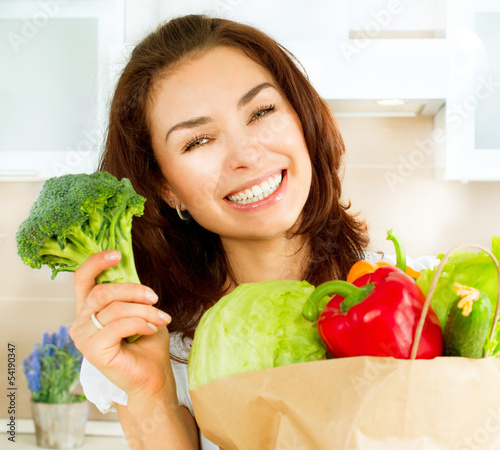 Photo: Happy Young Woman with vegetables in shopping bag. Diet Concept Happy Young Woman with vegetables in shopping bag. Diet Concept