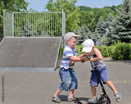 Photo: Two young boys fighting over a scooter Two young boys fighting over a scooter