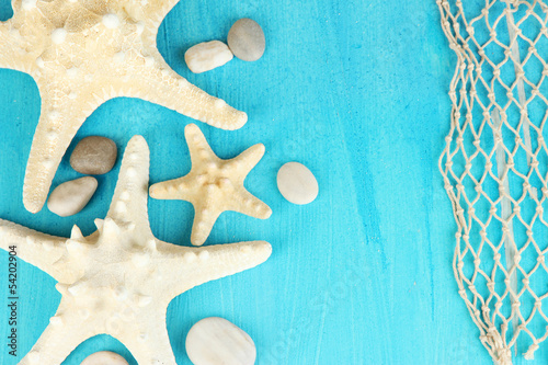 Photo: White starfishes on blue wooden table close-up White starfishes on blue wooden table close-up