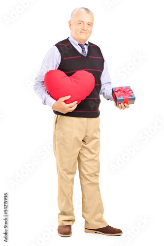 Photo: Mature gentleman holding a heart and gift Mature gentleman holding a heart and gift