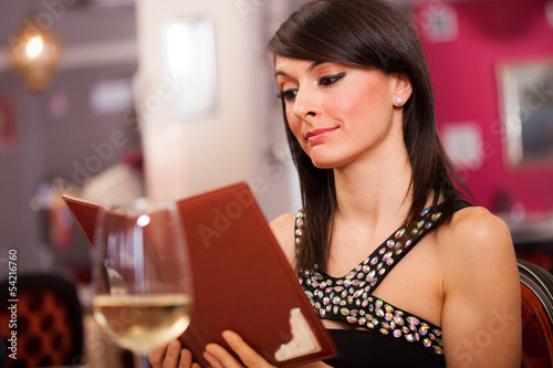 Photo: Woman reading a menu Woman reading a menu