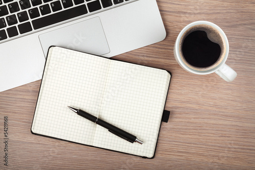 Photo: Notepad, laptop and coffee cup on wood table Notepad, laptop and coffee cup on wood table