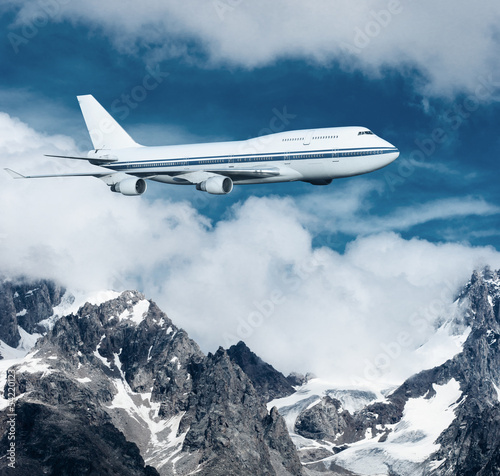 Photo: plane flying over the snow-capped mountains. plane flying over the snow-capped mountains.