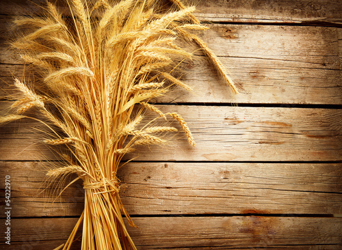 Photo: Wheat Ears on the Wooden Table. Harvest concept Wheat Ears on the Wooden Table. Harvest concept