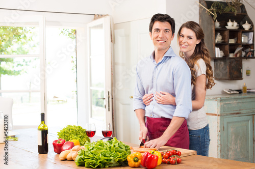 Photo: Happy Young Couple Working In Kitchen Happy Young Couple Working In Kitchen