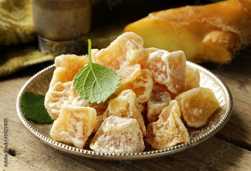 Photo: sugared ginger (candied) and fresh root on a wooden table sugared ginger (candied) and fresh root on a wooden table