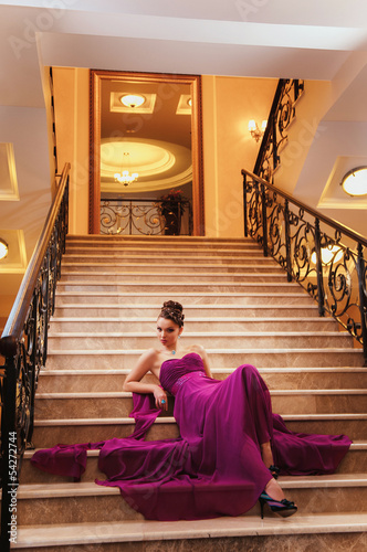 Photo: woman in a long dress is sitting on the stairs woman in a long dress is sitting on the stairs