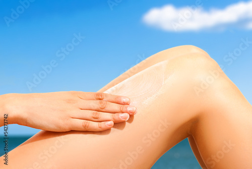 Photo: Woman applying sunscreen on her skin Woman applying sunscreen on her skin