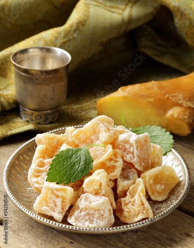 Photo: sugared ginger (candied) and fresh root on a wooden table sugared ginger (candied) and fresh root on a wooden table