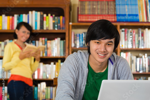 Photo: Man in library with laptop Man in library with laptop