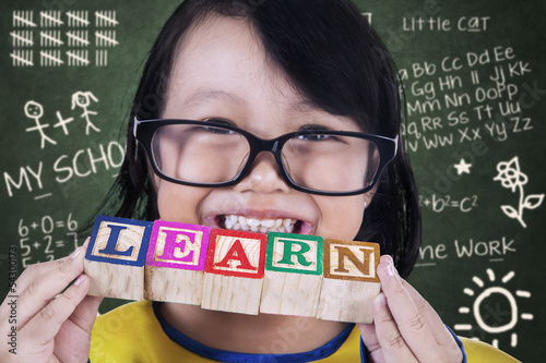 Photo: Close-up girl graduate hold learn wooden toy in class Close-up girl graduate hold learn wooden toy in class