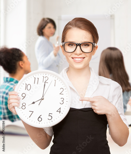 Photo: attractive student pointing at clock attractive student pointing at clock