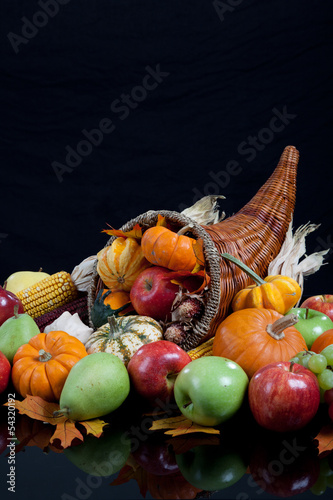 Photo: An overflowing cornucopia on a black background An overflowing cornucopia on a black background