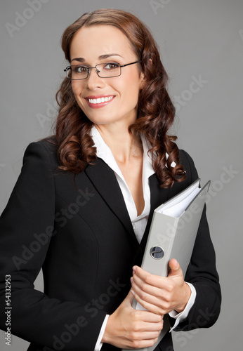Photo: Businesswoman with folder, on gray Businesswoman with folder, on gray