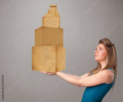 Photo: Young lady holding a set of brown cardboard boxes Young lady holding a set of brown cardboard boxes